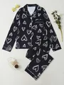 Close-up detail of women's black long-sleeved pajama set featuring white heart outlines - S / Top And Bottom / Black