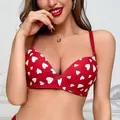 Detailweergave van een rode naadloze beha met een romantisch wit hartjesprintpatroon. - Rood