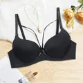 Elegant black push-up bra featuring cage-style front straps displayed on a white fur rug - Black