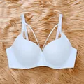Detailed view of a white push-up bra with unique front cross-strap design on fur background - 34/75B / Tops / White