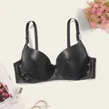 Detail view of a sexy black PU leather push-up bra with textured dot pattern. - 34/75B / Tops / Black