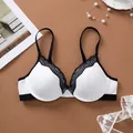 Detail shot of elegant white bra with black lace trim and adjustable straps - 70B / Tops / Black and White