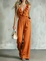 Full length view of a chic burnt orange V-neck sleeveless jumpsuit with ruffle details - Orange Red