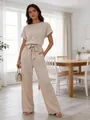 Full-body view of an elegant woman in a beige short-sleeved wide-leg jumpsuit indoors - XS / Top And Bottom / Off White
