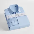 Premium men's light blue long-sleeved mulberry silk blend shirt folded neatly on white. - 38 / Tops / Blue
