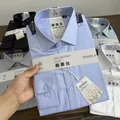 Detailed macro view of folded mulberry silk blend men's dress shirts with product tags - 38 / Tops / Light Blue