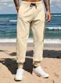 Detailed view of men's beige joggers in a relaxed fit with cuffed ankles. - S / Bottoms / Khaki