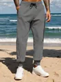 Detail of men's grey casual joggers with elastic drawstring waist and ribbed cuffs. - S / Bottoms / Dark Gray