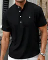 Close-up of black short-sleeved Henley shirt with white buttons and chest pocket - Black