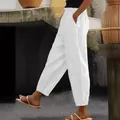 Side view of white cotton linen trousers featuring elastic waist and side pockets. - S / Bottoms / White