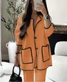 Vista detallada de la tela naranja vibrante y el ribete ondulado negro en este conjunto - XS / Top Y Pantalón / Naranja