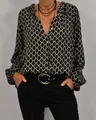 Detail einer eleganten Damenbluse mit V-Ausschnitt, Langarm und geometrischem Muster - S / Oberteile / Schwarz