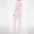 Back view detail of women's pale pink long-sleeve top and flared trousers set - XS / Top And Bottom / Pink