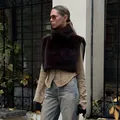Detail view of a dark brown faux fur snood vest on a model in an outdoor setting. - S / Tops / Brown
