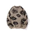Detailed view of beige knitted sweater featuring bold black jacquard eye patterns - M / Tops / Apricot and Black