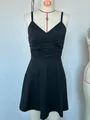 Close-up front view of a minimalist black V-neck slip dress displayed on a professional mannequin - XS / Top And Bottom / Black