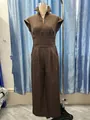 Detailed view of a brown sleeveless v-neck jumpsuit with waist pleats on a mannequin - XS / Top And Bottom / Coffee