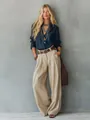Full length view of elegant women's high-waisted beige wide-leg trousers with draped fabric. - S / Bottoms / Apricot