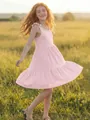 A smiling girl wears a pink sleeveless tiered dress in a sunlit field detail view. - 110cm / Top And Bottom / Lotus Pink