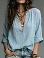 Detail view of light blue V-neck linen tunic featuring rolled sleeves and layered necklaces - S / Tops / Light Blue