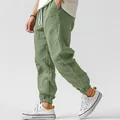 Close-up detail of men's sage green cotton linen joggers showing fabric texture and fit - Light Green