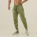 Detailed view of sage green men's athletic joggers with drawstring and tapered fit - M / Bottoms / Yellow-Green
