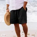 Pantaloncini mare neri in lino da uomo con coulisse, sulla spiaggia con cappello. - Nero