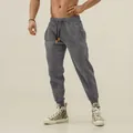 Detail view of men's grey athletic joggers with tapered cuffs and zipper pockets - M / Bottoms / Dark Gray