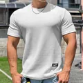 Close-up of white waffle knit short-sleeved fitness t-shirt with textured fabric detail. - M / Tops / White