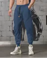 Detail view of men's blue paneled sports joggers featuring elastic waist and drawstrings. - Navy Blue
