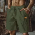 Close-up of men's army green cotton linen shorts with drawstring and patch detail - S / Bottoms / Army Green