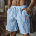 Close-up detail of men's light blue cotton linen shorts with drawstring waist and leather patch - S / Bottoms / Light Blue