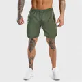 Vestibilità atletica e dettaglio del tessuto traspirante dei pantaloncini verdi sul modello - Verde chiaro