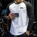 Close-up of men's black and white raglan long sleeve fitness shirt with chest logo - Tops / M / Black and White Sleeves