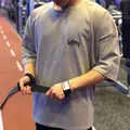 Gros plan d'un homme portant un t-shirt de fitness gris oversize en plein effort - M / Hauts / Kaki