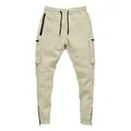 Detailed view of beige men's slim-fit cargo joggers with drawstring waist and pockets. - Beige