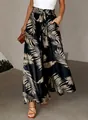 Close-up of high-waisted wide-leg pants with tropical leaf print and drawstring waist - S / Bottoms / Black With Brown Palm Leaves