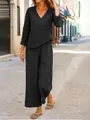 Elegante completo nero con top a scollo a V e pantaloni larghi in una via tipica - Nero