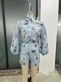 Dettaglio del set due pezzi moda casual con camicetta e pantaloncini a stampa floreale - Taglia S / Top E Pantaloni / Azzurro