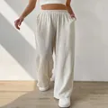 Close-up of beige wide-leg trousers showing the elastic waistband and linen texture details - S / Bottoms / Apricot
