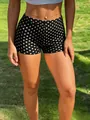 Close-up of women's Y2K polka dot high-waisted sports shorts with a slim fit on green grass. - Bottoms / Shorts/S / Black Polka Dot