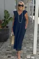 Outdoor lifestyle shot of a navy blue cotton linen maxi dress with flutter sleeves - S / Bottoms / Navy Blue