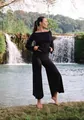 High-waisted black yoga pants with irregular hems in a natural waterfall setting. - Black