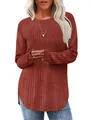 Close-up of the ribbed fabric and unique curved high-low hem on this red-brown sweater - Caramel color