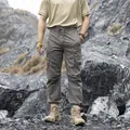 Men's grey functional cargo pants with multi-pockets in outdoor rocky setting. - 28 / Bottoms / Grey Green