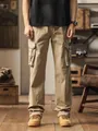 Men's loose khaki straight-leg cargo pants with multi-pockets in a vintage indoor setting - 28 / Bottoms / Khaki