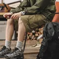 Men's classic olive green cotton cargo shorts displayed in a casual outdoor lifestyle setting - Military Yellow