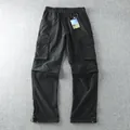 Detailed flat lay of men's black convertible cargo pants featuring multiple pockets. - M / Bottoms / Black