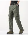 Detalle de pantalones cargo verdes para hombre con bolsillos laterales y corte recto. - Verde Hierba