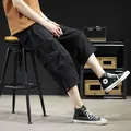Men's black cargo shorts featuring multiple pockets and drawstring hem in a relaxed casual fit - Black